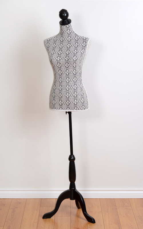 A stylish dress form mannequin with a delicate lace cover, standing on a black wooden base, perfect for displaying and designing garments.